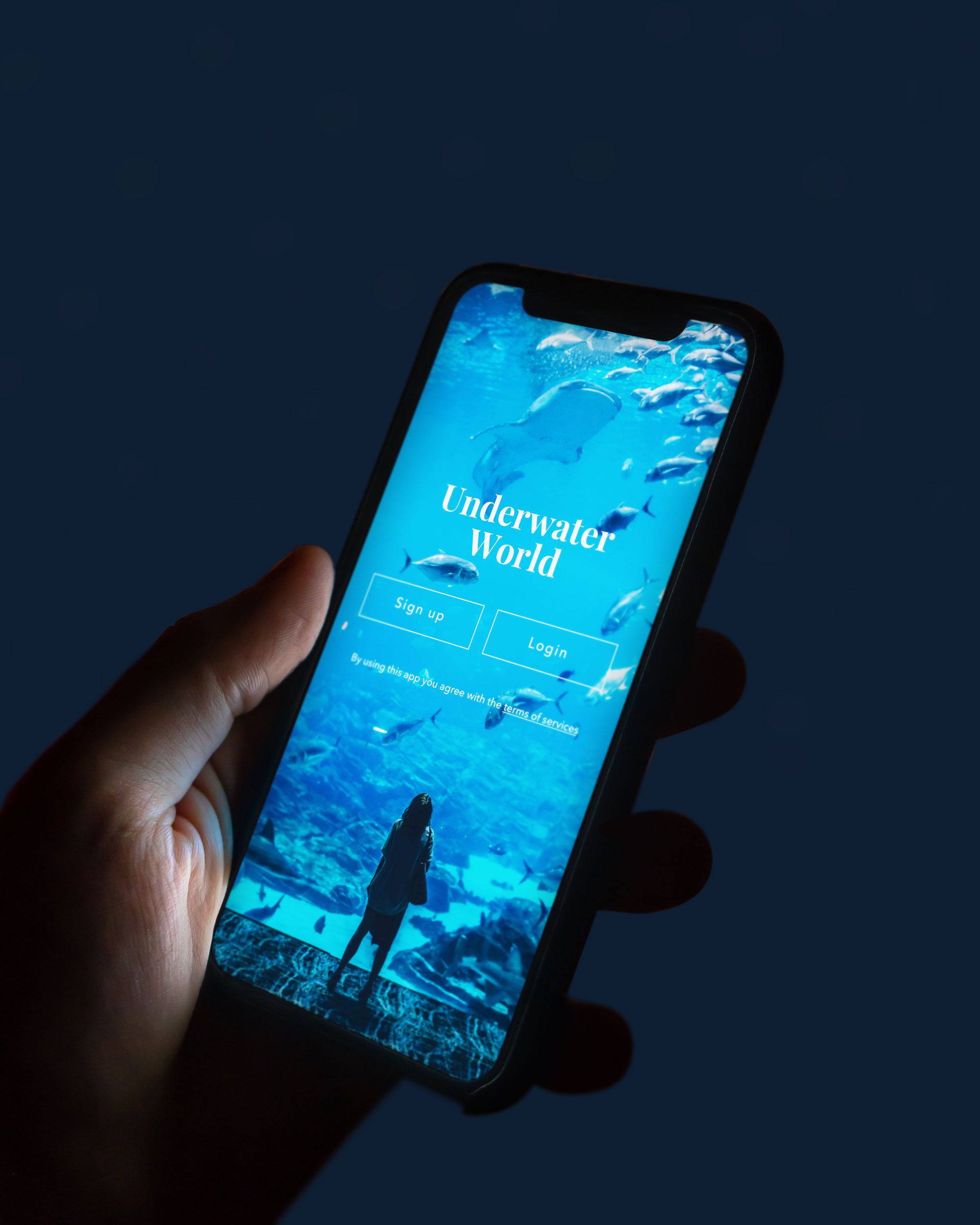 Person holding phone with Underwater World app main screen